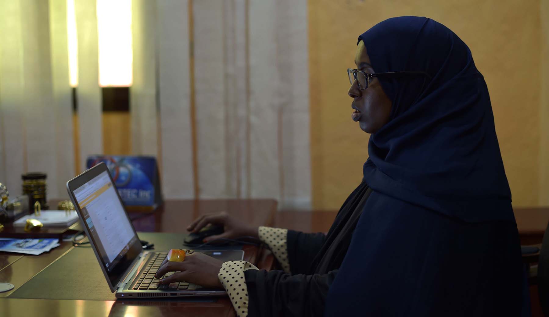 Photo of Sahra Abdikarim Ibrahim using a laptop computer.